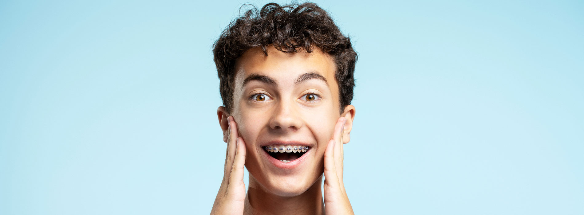 The image shows a person with their mouth open, expressing surprise or excitement, against a light blue background.