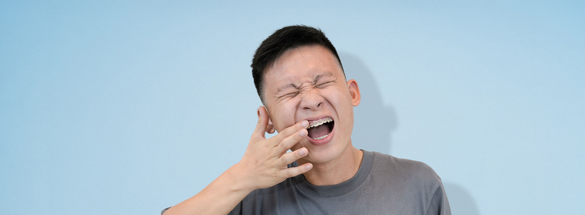 The image features a person with their mouth open, possibly singing or speaking, against a blue background.