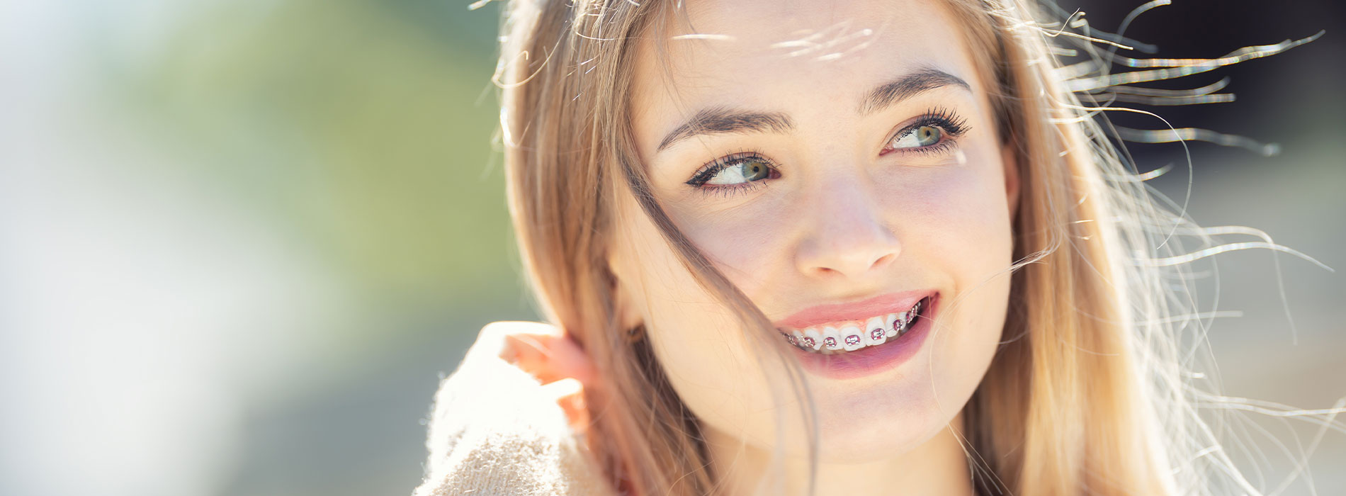 The image features a young woman with long hair smiling at the camera.